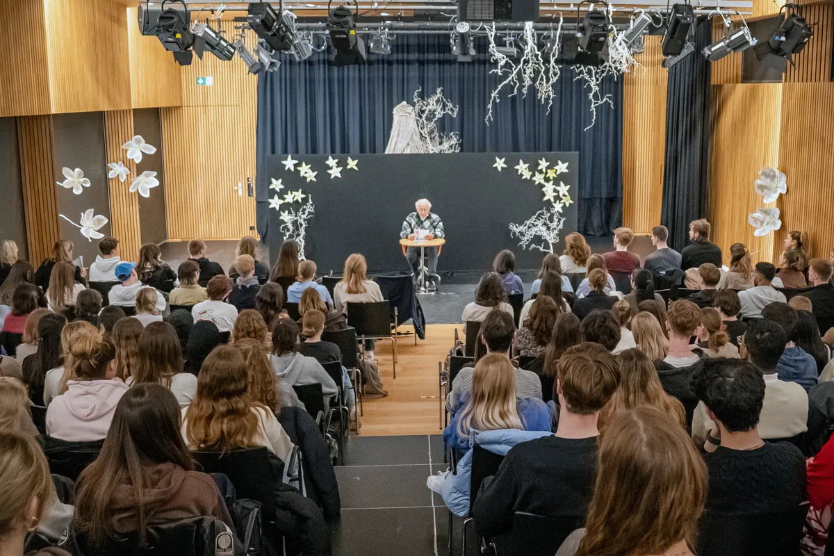 Vor gefüllten Sitzreihen erzählt der Holocaust-Überlebende seine Geschichte. Holocaust-Zeitzeuge hält Vortrag im Bildungszentrum in Uster.
